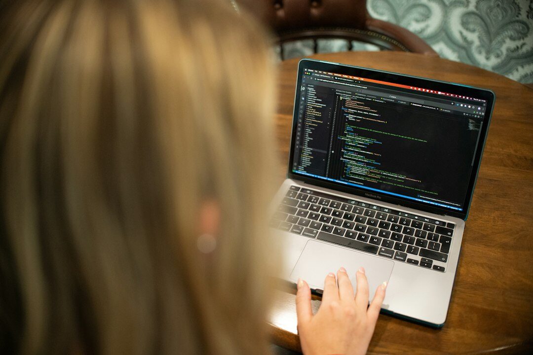programmer typing code on laptop